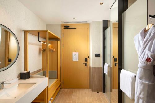 a bathroom with a sink and a mirror at Hilton Garden Inn Shenzhen Airport in Shenzhen