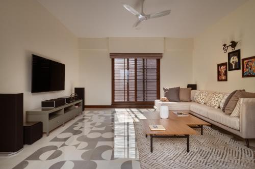 a living room with a couch and a tv at Melhor stays Villas - UL- C2 7BHK villa with private pool, Assagao in Assagao