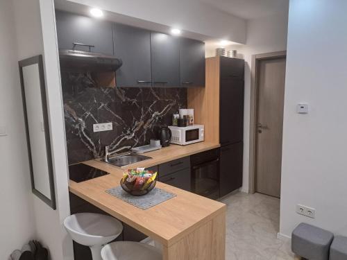 una cucina con bancone, lavandino e forno a microonde di Apartman Pariz a Slavonski Brod