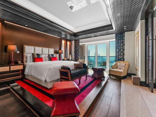 Rixos Marina Abu Dhabi في أبوظبي: غرفة نوم بسرير كبير وسجادة حمراء