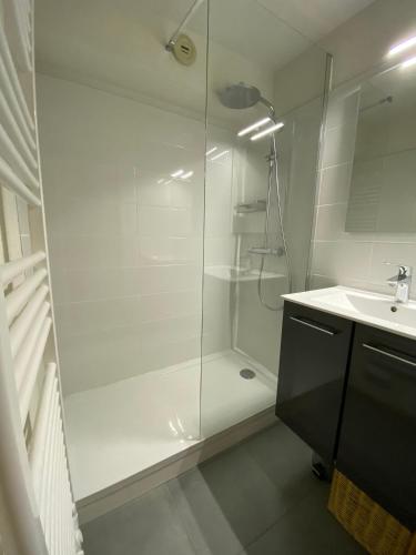 une salle de bain blanche avec une douche et un lavabo dans l'établissement Appartement centre d'Arêches, 4 personnes, 1 chambre, 1 coin montagne - VLII36, à Beaufort