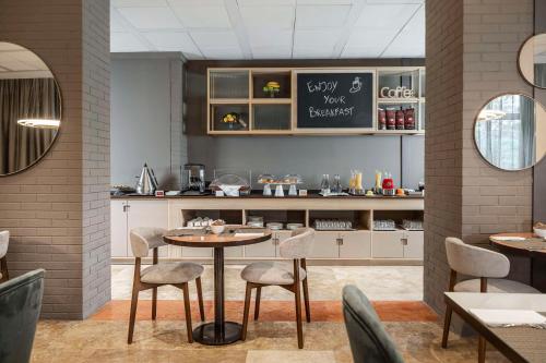 a restaurant with a table and chairs and a counter at Hilton Garden Inn Bologna North in Bologna