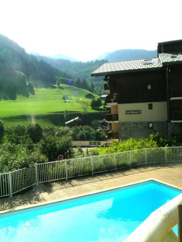 une piscine bleue en face d'un bâtiment dans l'établissement Appartement centre d'Arêches, 4 personnes, 1 chambre, 1 coin montagne - VLII36, à Beaufort