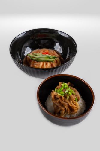 two black bowls of food on a white table at Sayang Sanur Duplex in Sanur