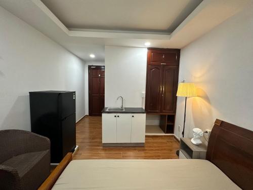 een kamer met een bed en een keuken met een wastafel bij Taibo house 2 in Ho Chi Minh-stad