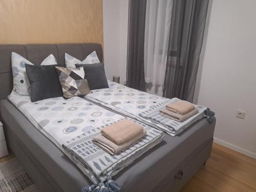 a bed with pillows on it in a bedroom at Apartman Pariz in Slavonski Brod