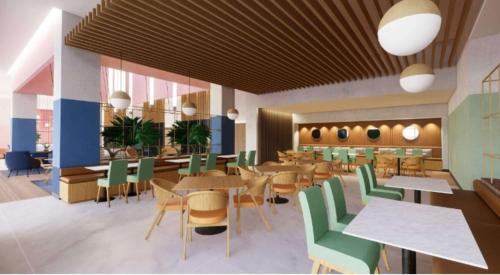 a restaurant with wooden tables and green chairs at Hilton Garden Inn San Jose Airport City Mall in Alajuela
