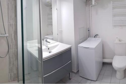a white bathroom with a toilet and a sink at Modern Home proche de Disneyland et Paris in Champs-Sur-Marne