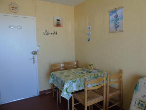 une salle à manger avec une table, des chaises et une porte dans l'établissement Le Grand Cap Jaune, à Saint-Jean-de-Monts