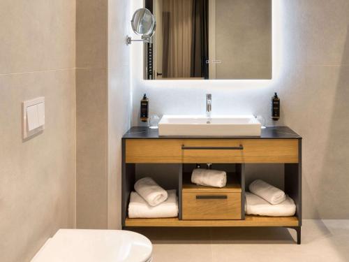 uma casa de banho com um lavatório e um espelho em Mercure Tirana em Tirana