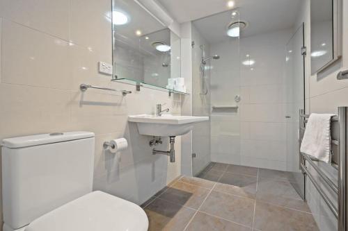 a bathroom with a toilet and a sink and a shower at Trendy 3 Level Retreat at North Melbourne with parking in Melbourne
