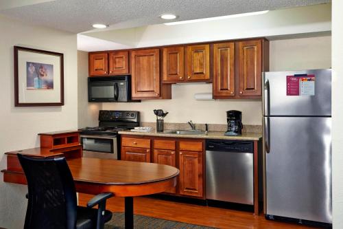 a kitchen with a table and a stainless steel refrigerator at Residence Inn Minneapolis Eden Prairie in Eden Prairie