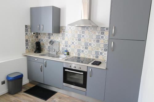 une petite cuisine avec un évier et une cuisinière dans l'établissement Studio proche de la mer, à Portel-des-Corbières