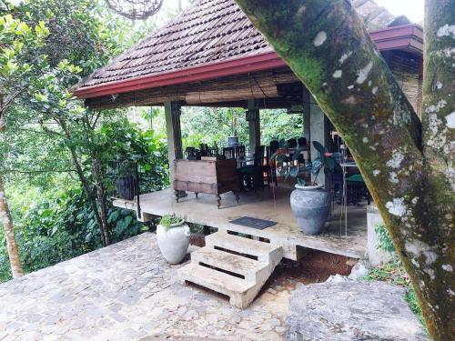 a pavilion with a table and chairs on a patio at The Annex By Jansen's Bungalow Sinharaja Rainforest Retreat in Kalawana