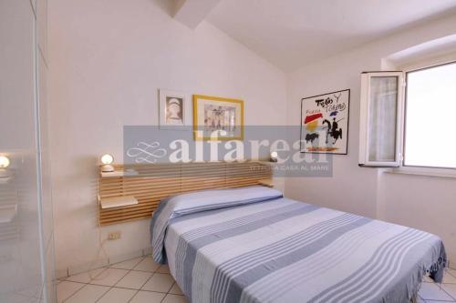 een slaapkamer met een bed in een witte kamer bij Mare Bilo in Castiglione della Pescaia