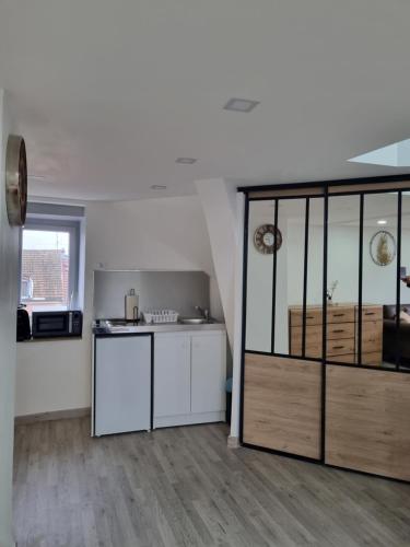 une cuisine avec des armoires blanches et un comptoir dans l'établissement Bel appt centre ville /gare, à Belfort