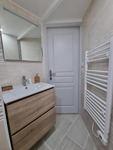 La salle de bains est pourvue d'un lavabo, d'un miroir et d'une porte. dans l'établissement Bel appt centre ville /gare, à Belfort