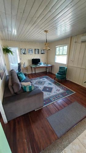 ein Wohnzimmer mit einem Sofa und einem Tisch in der Unterkunft Casa das Plantas in Gravatal