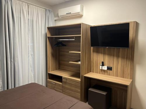 um quarto de hotel com uma televisão e uma cama em Hotel Esperia em Sanremo