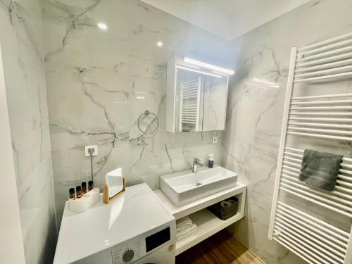 a white bathroom with a sink and a mirror at Leonidas House in Chania