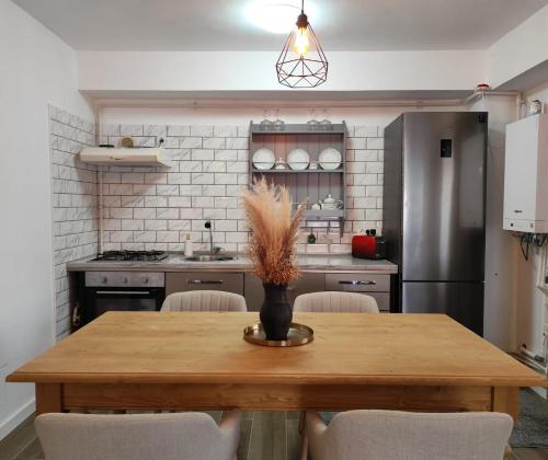 a kitchen with a wooden table with chairs and a refrigerator at Vila Didi, Mangalia in Mangalia