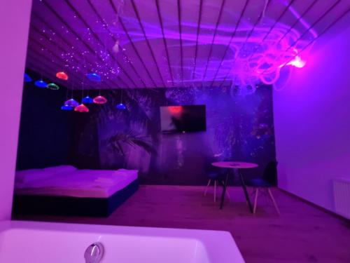 fioletowy pokój z wanną, łóżkiem i stołem w obiekcie Jacuzzi Katowice - Avatar w mieście Katowice