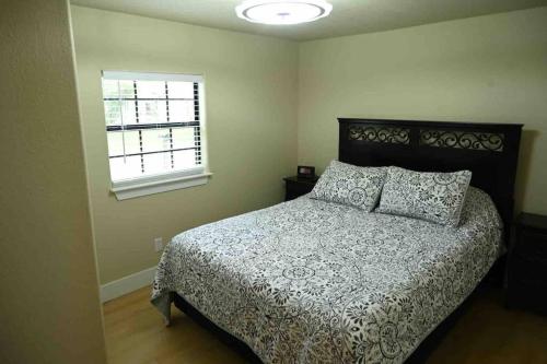 a bedroom with a bed with a comforter and a window at 1 Block to Lake Eufaula! in Eufaula