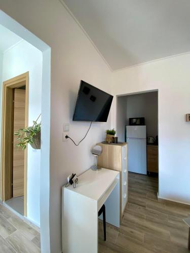 a living room with a table and a tv on the wall at The Garden Studio 2 in Kriopigi