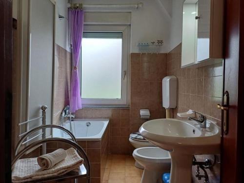 La salle de bains est pourvue d'un lavabo, de toilettes et d'une fenêtre. dans l'établissement Casa vacanza Leonardo, à Chambave