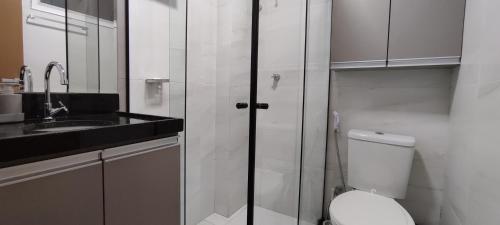 a white bathroom with a toilet and a sink at Flat 109 Paradise Beach in João Pessoa