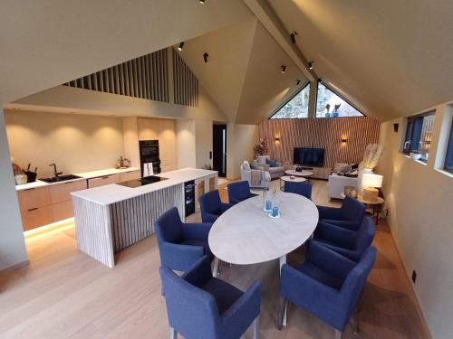 a kitchen and living room with a table and blue chairs at Perle ved sjøen! Ny hytte på 90m2. in Kragerø