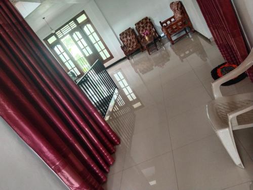 een woonkamer met rode gordijnen bij Green Haven Guest Inn in Badulla