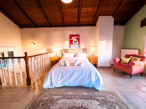 a bedroom with a large bed and a chair at Blue Bay Villa in Volos