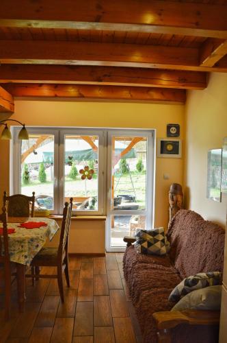 a living room with a couch and a table and window at Agroturystyka w Świcie in Tuchola
