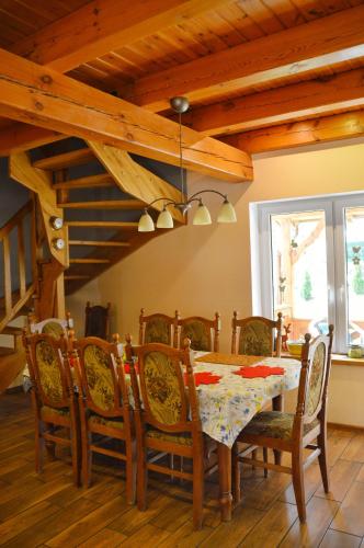 a dining room with a table and chairs and a staircase at Agroturystyka w Świcie in Tuchola