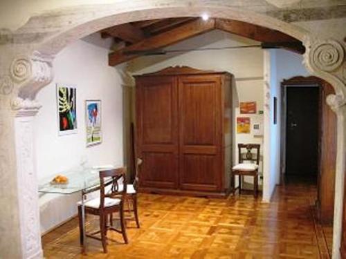 um quarto com uma mesa e cadeiras e um piso de madeira em B&B A Casa Di Andrea em Mantova