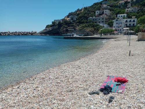 a beach with an umbrella on a rocky beach at Lydia Mare in Agios Kirykos