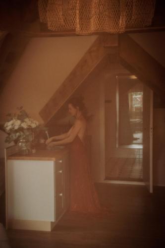 a woman in a dress standing in a room at Maison Bellefleur B&B - Pension in Renesse