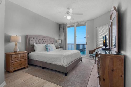 a bedroom with a bed and a desk with a television at Summerwind Center 1304 in Navarre