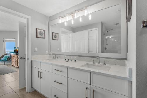 a white bathroom with a sink and a mirror at Summerwind Center 1304 in Navarre