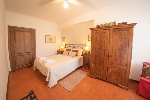 a bedroom with a bed and a large wooden cabinet at Agriturismo Parzalla in Ficulle