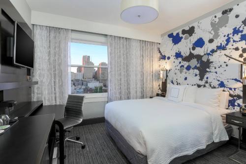 舊金山的住宿－舊金山聯合廣場萬怡酒店，配有一张床、一张书桌和一扇窗户的酒店客房