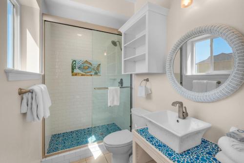 a white bathroom with a sink and a shower at Bonita Bay in Pensacola Beach