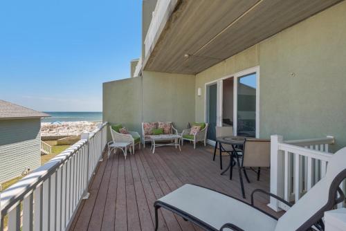 a balcony with a table and chairs and the ocean at Bonita Bay in Pensacola Beach