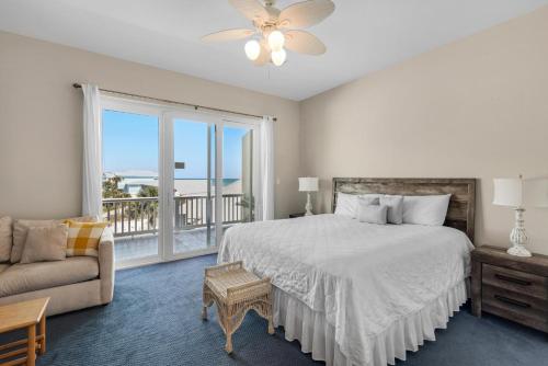 a bedroom with a bed and a couch and a large window at Bonita Bay in Pensacola Beach