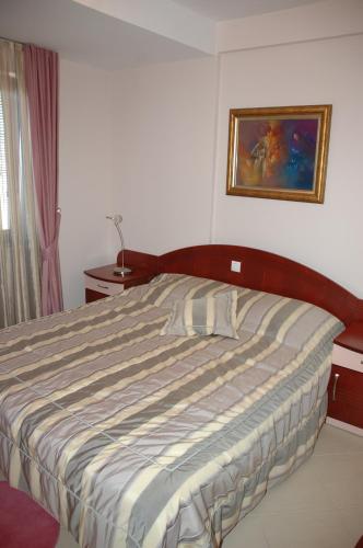 a bed in a bedroom with a picture on the wall at Villa Mia Suites in Ohrid