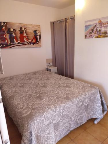 une chambre avec un lit et un tableau au mur dans l'établissement T1 bis à 50 m de la plage, à Sainte-Maxime