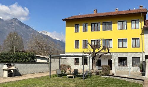 a yellow building with a tree in front of it at A due passi dal lago in Montalto Dora