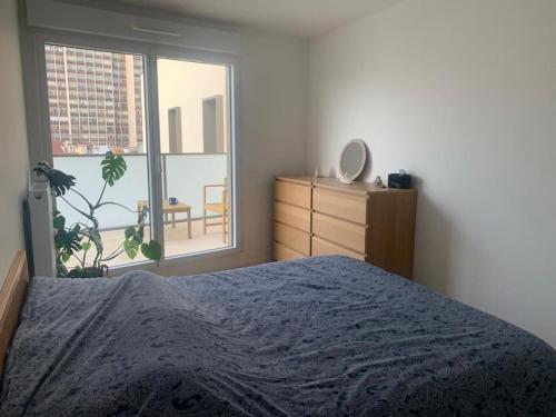 une chambre avec un lit, une commode et une fenêtre dans l'établissement Grand Appartement Proche Paris Idéal Paris 2024, à Ivry-sur-Seine