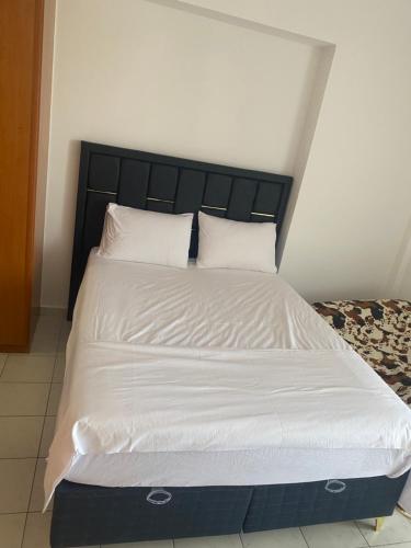 a large bed with white sheets and pillows at Studio Ria Gallou in Gállos